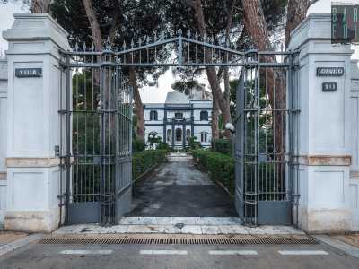 A introdurla � un elegante cancello nero incastonato tra due alte colonne in pietra di tufo che riportano il nome dell�edificio...